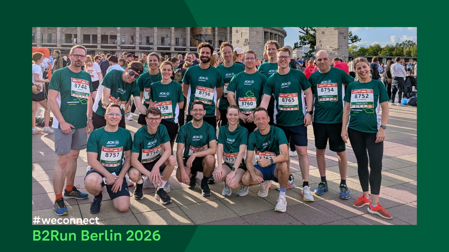16 Teilnehmende von AOK connect beim B2Run Berlin 2026 vor dem Olympiastadion in Berlin mit Startnummern und Laufshirts.